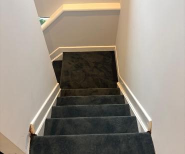 Vue plongeante sur un escalier en tapis anthracite