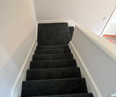 Escalier terminé avec un tapis anthracite posé sur mesure
